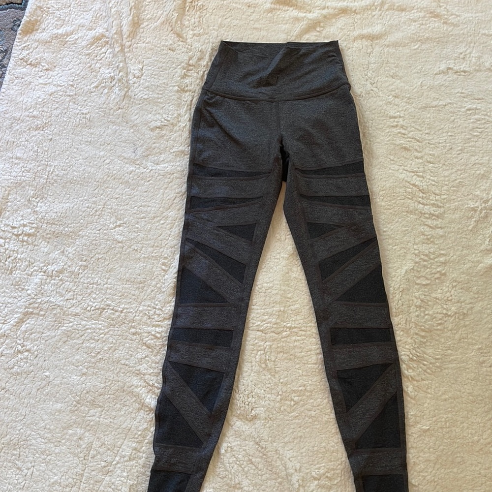 Lululemon gray legging with cross stitched patches across the front of the legs